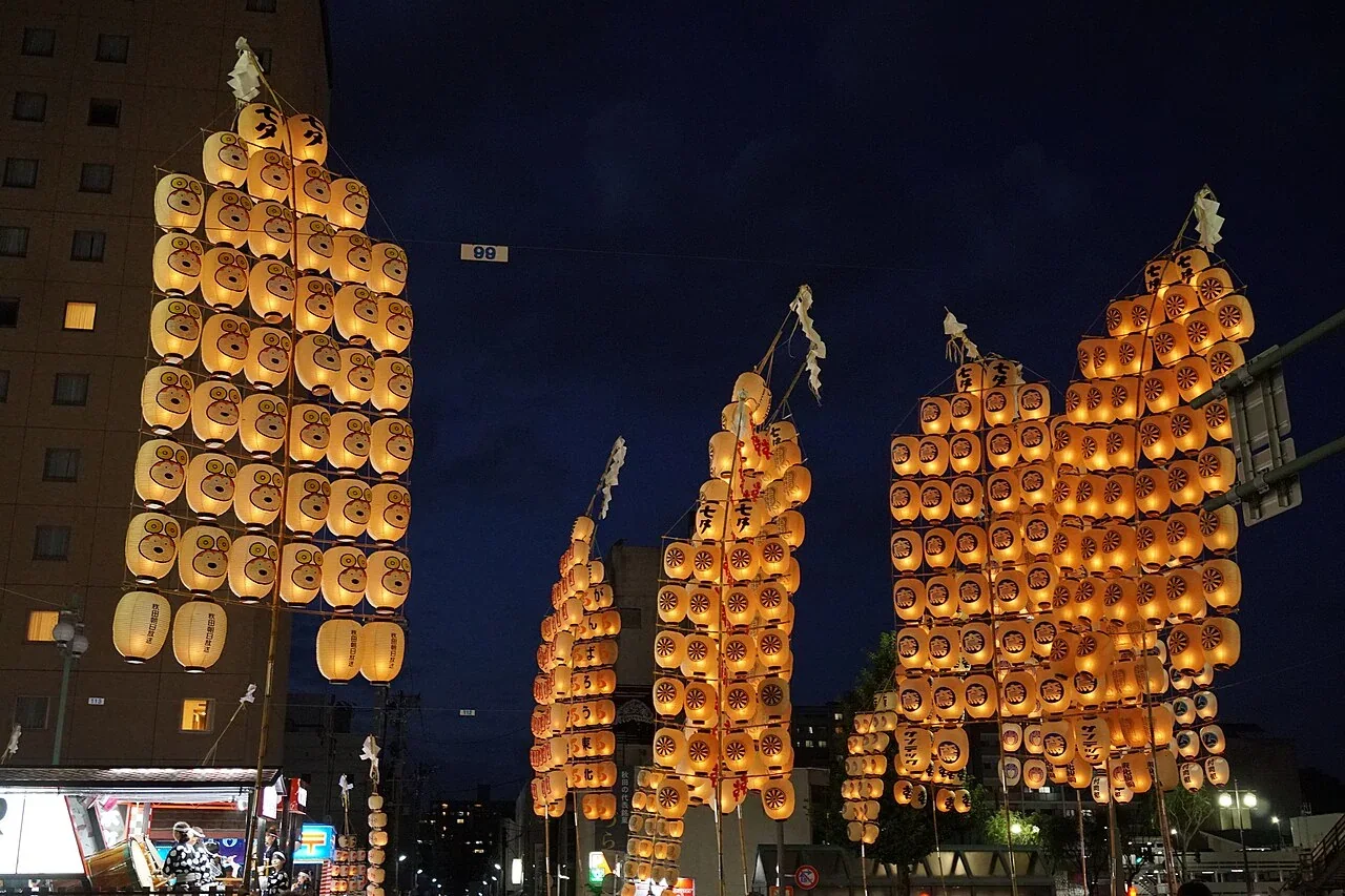 秋田竿燈祭表演者高舉掛滿燈籠的竹竿（歷年活動照片）