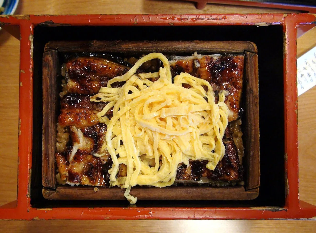 柳川鰻魚蒸籠飯，上方鋪有鰻魚與金黃色蛋絲